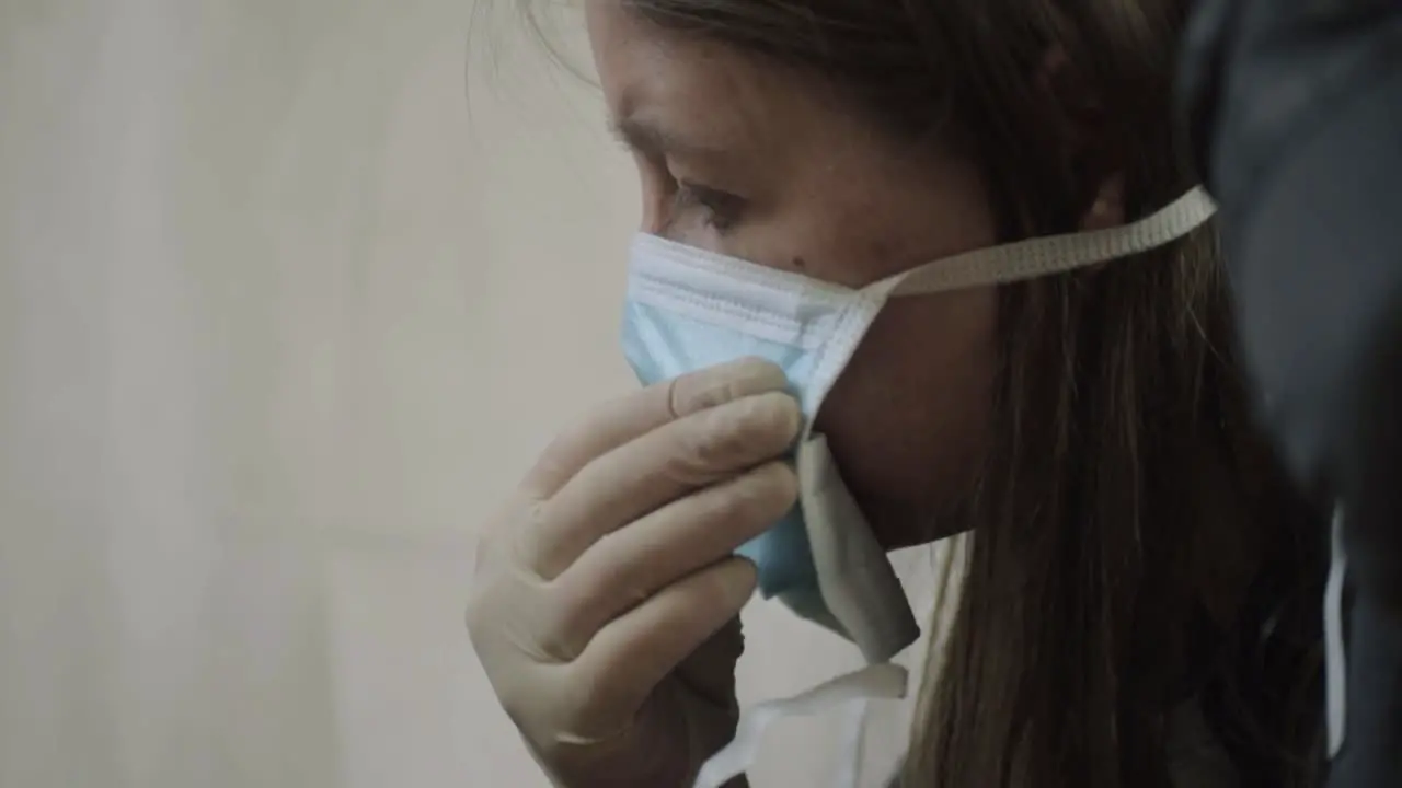 Woman wearing surgical gloves putting on surgical mask medium head shot