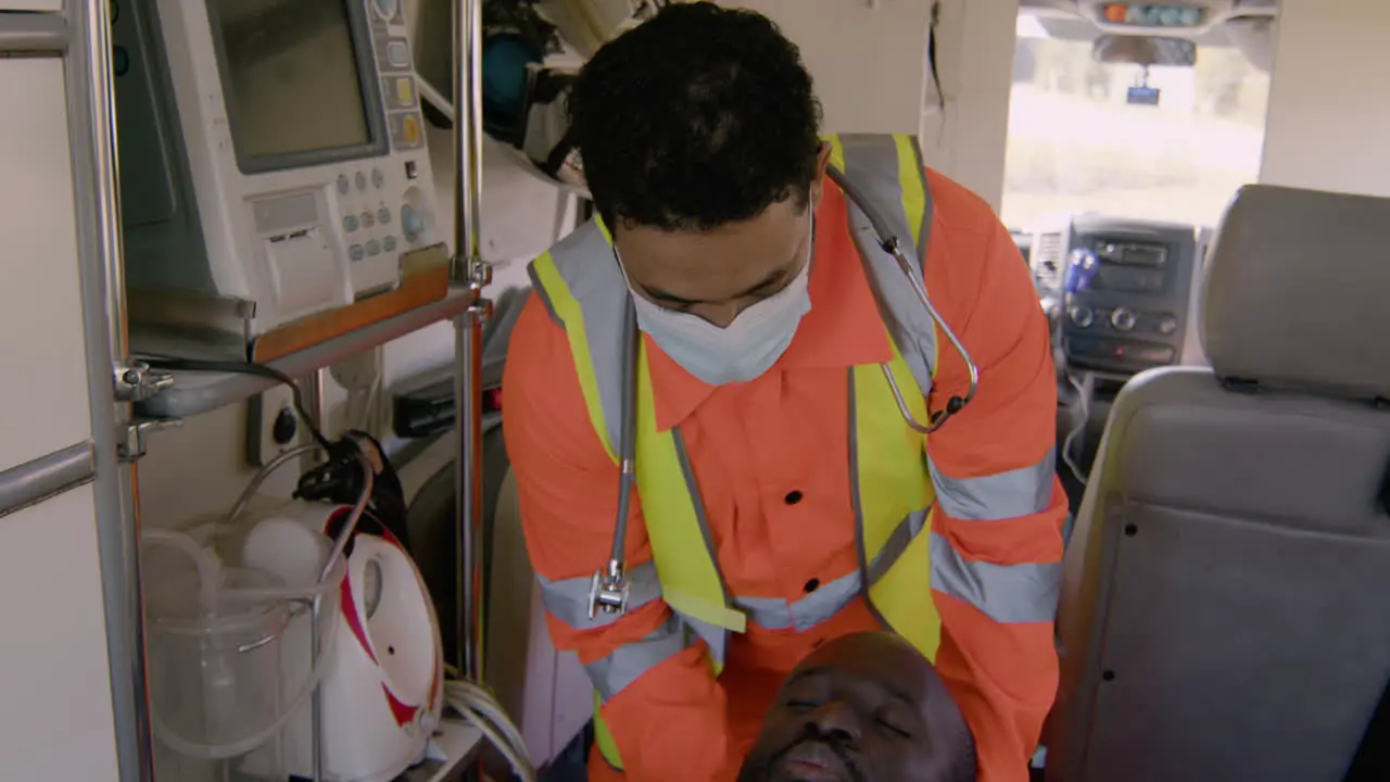 Paramedic Properly Positioning The Head Of A Patient Lying On A Stretcher Inside An Ambulance