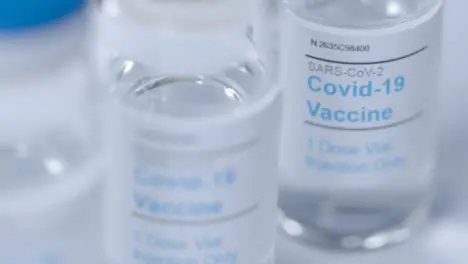 Sliding Extreme Close Up Shot of Several Coronavirus Vaccine Vials 