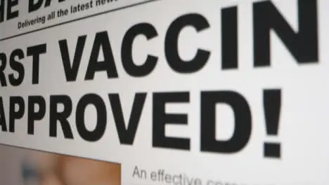 Dolly Out Extreme Close Up Shot of Coronavirus Vaccine News Article Scrolling On Computer Screen