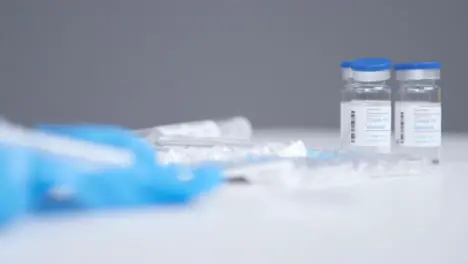 Tracking Shot Passing Over a Table with Covid 19 Vaccine Medical Items 