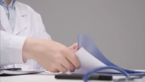 Pedestal Shot Revealing Medical Professional Going Through Documents at His Desk