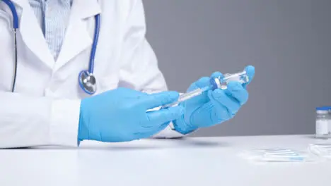 Medium Shot of Medical Professional Extracting Covid 19 Vaccine from Vial Using Syringe