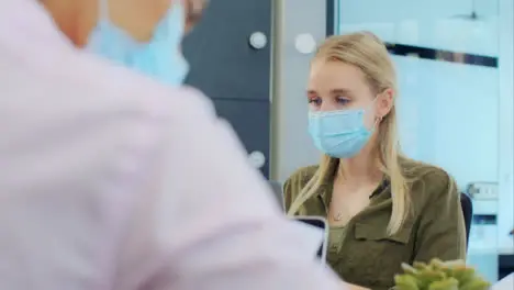 Over the Shoulder of Woman In Face Mask On Laptop