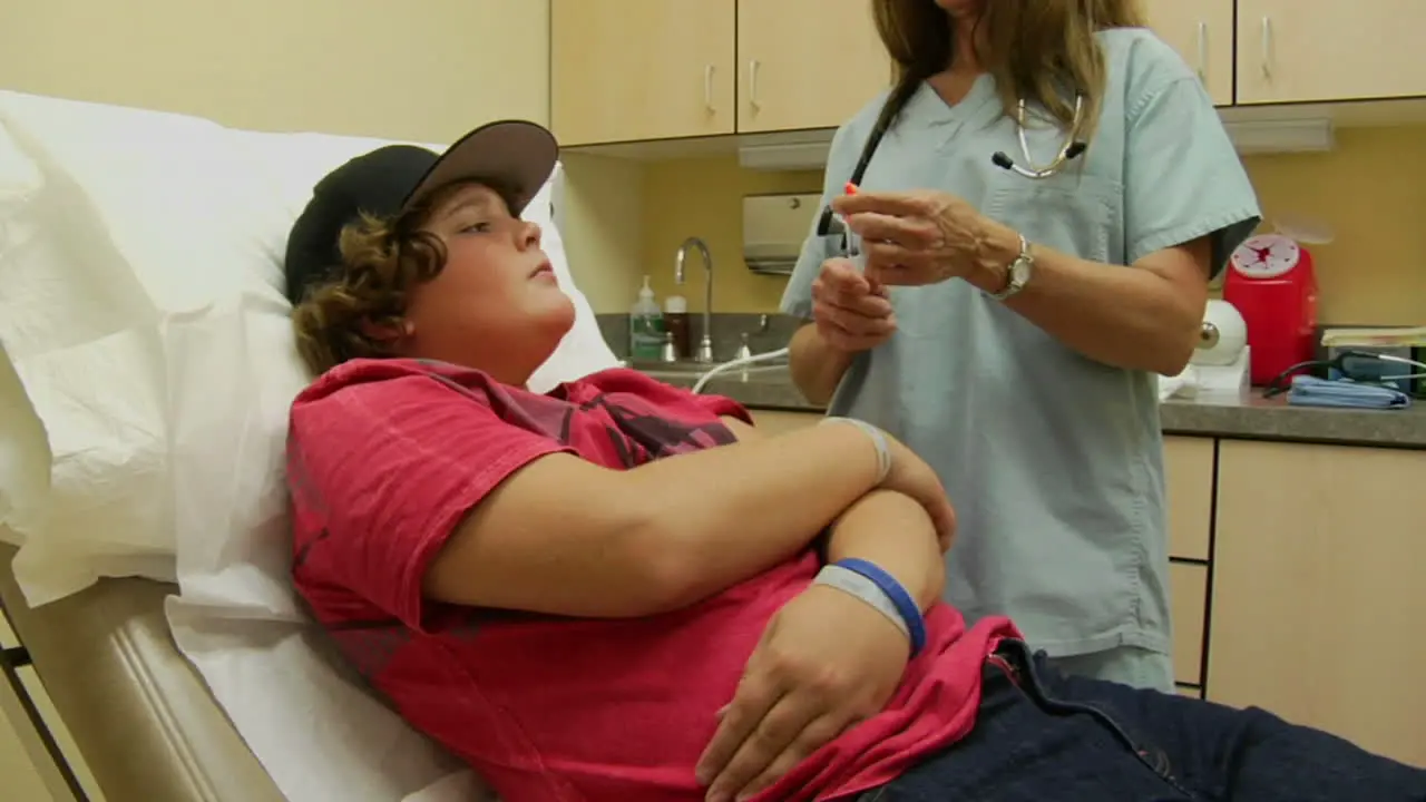 A nurse gives a worried patient a shot