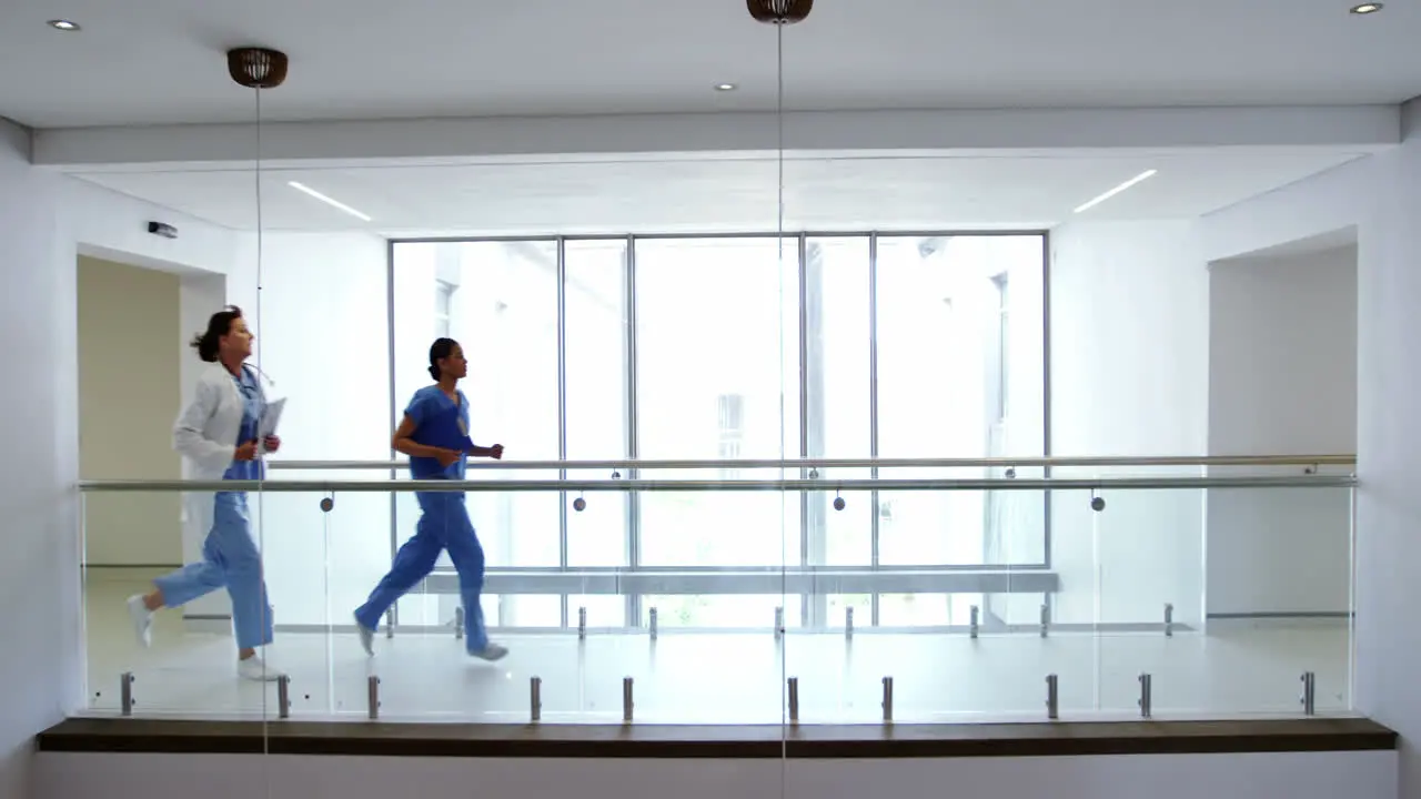 Doctor and nurse running in passageway of hospital 