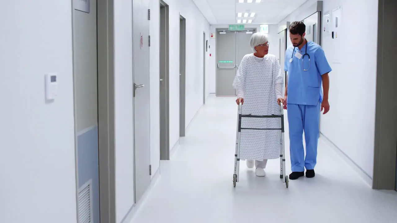 Male nurse assisting senior patient in using a walking frame