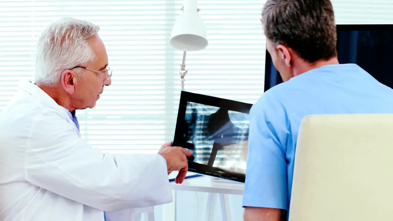 Male doctor discussing x-ray report with a patient