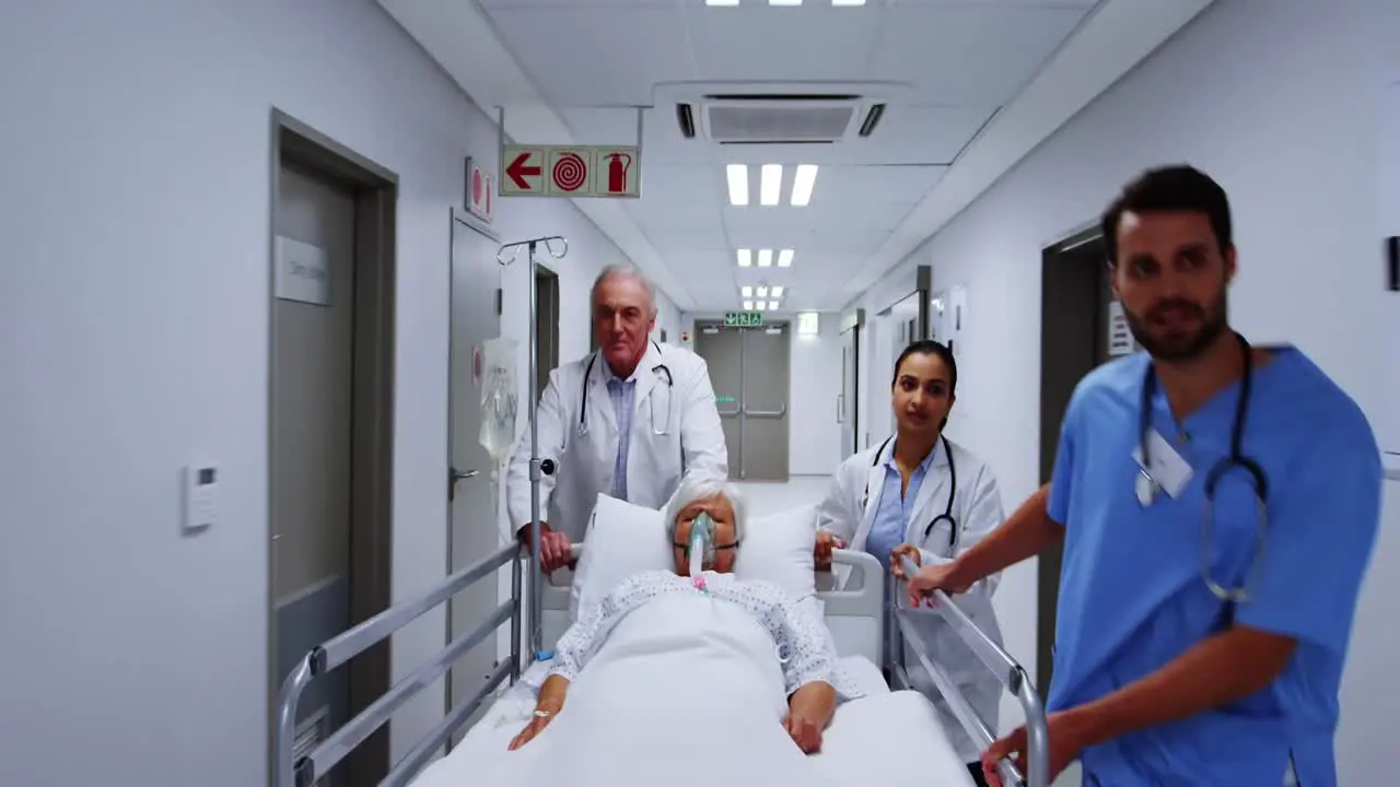 Doctors and nurse pushing emergency stretcher bed in corridor