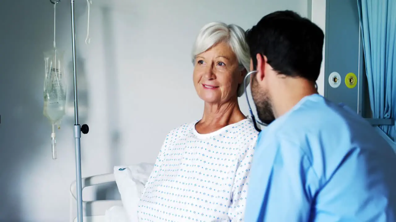 Nurse having a converstaion with smiling female senior patient