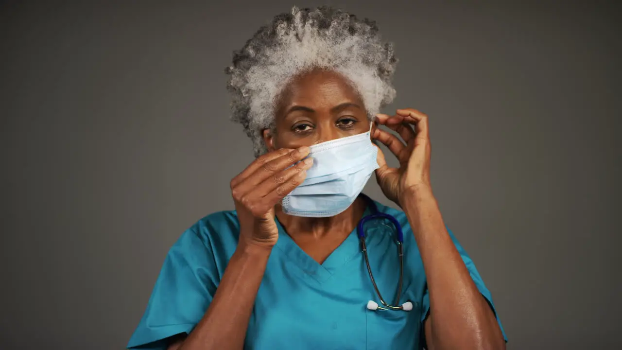 Middle Aged Doctor Putting On Face Mask Portrait