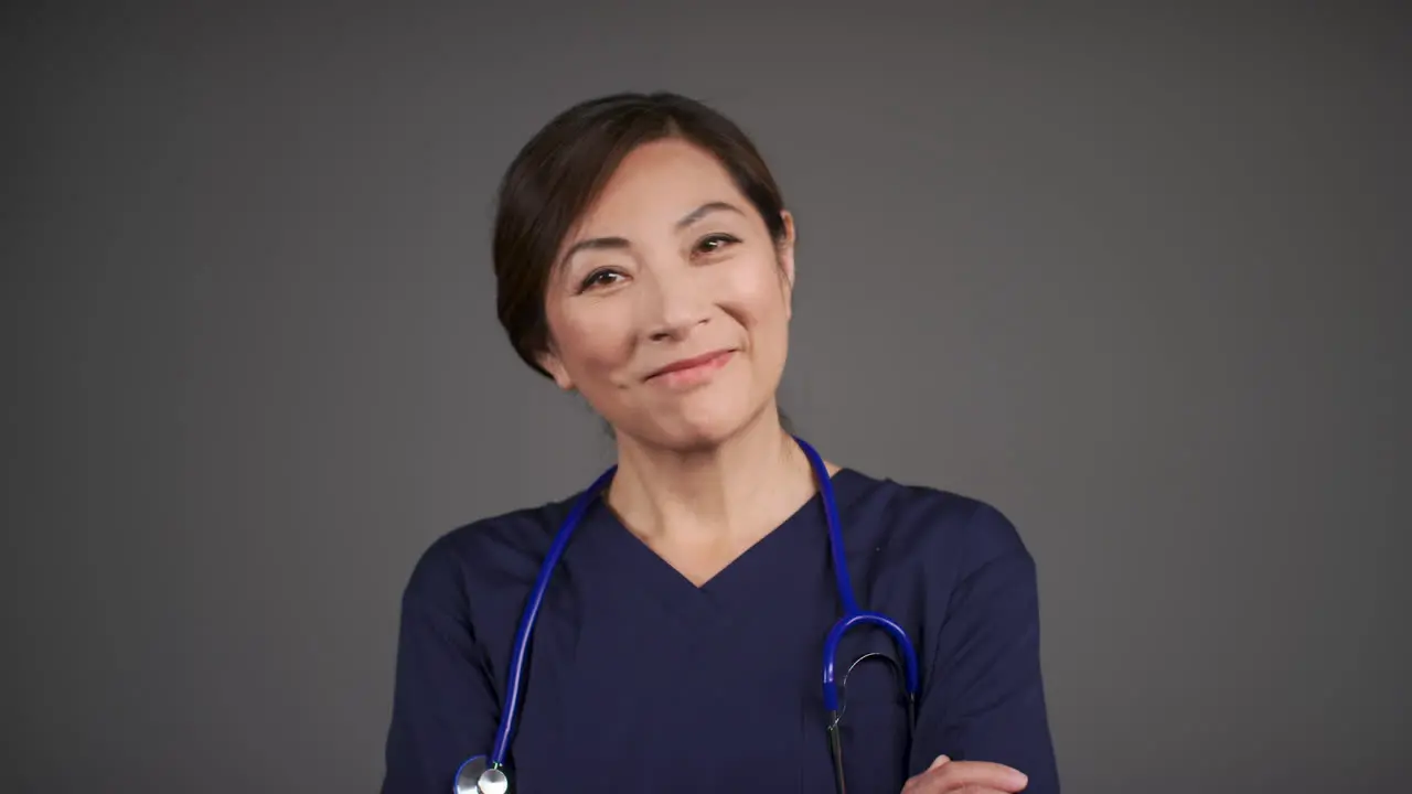 Pull Focus of Middle Aged Doctor Folding Her Arms and Smiling