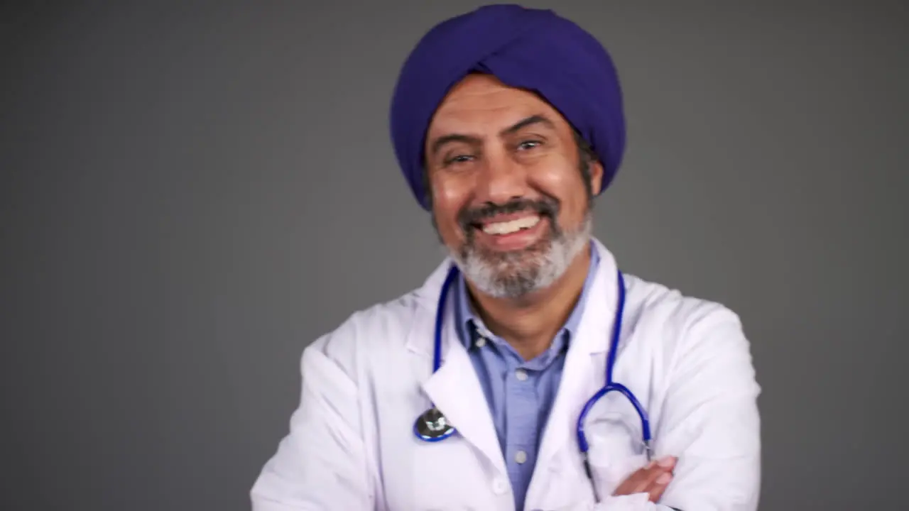 Pull Focus of Middle Aged Doctor In Turban Folds Arms and Smiles