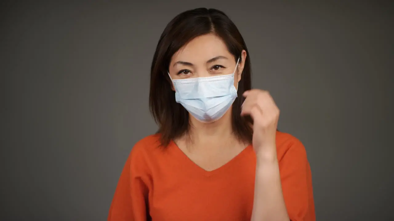 Middle Aged Woman Removing Face Mask and Smiling