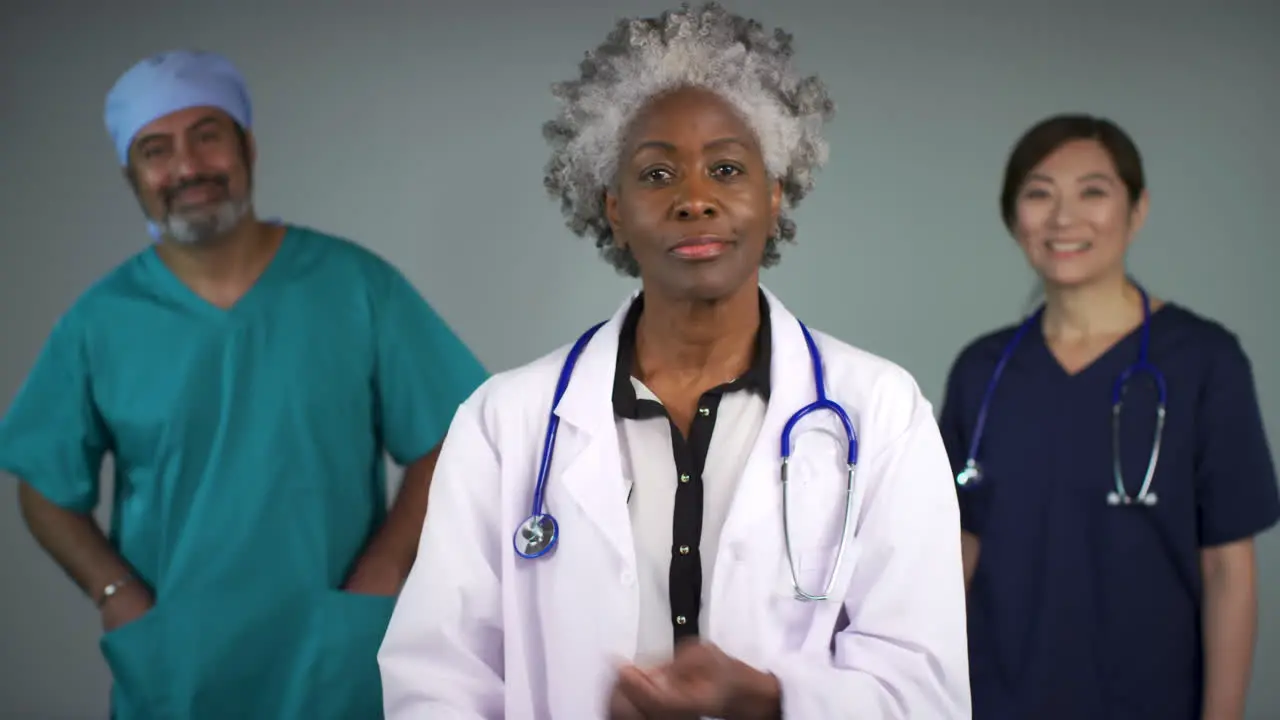 Pull Focus of Three Approachable Middle Aged Doctors Smiling Portrait