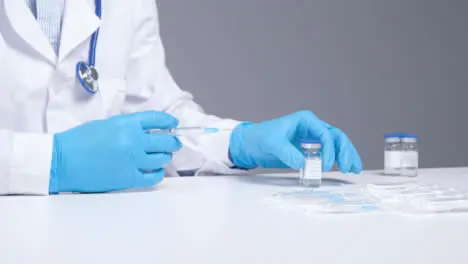 Medium Shot of Medical Professional Preparing Syringe for Covid 19 Vaccine 