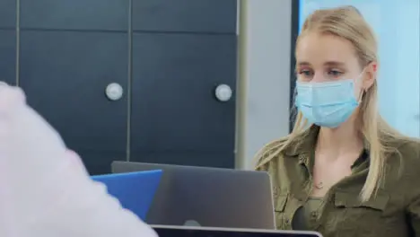 Over the Shoulder of Woman In Face Mask Reading Notebook