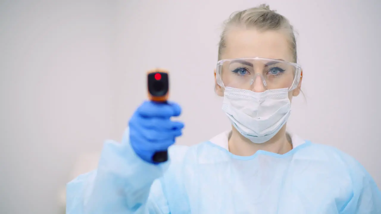 Doctor Measuring Patient Temperature At Health Care Clinic 