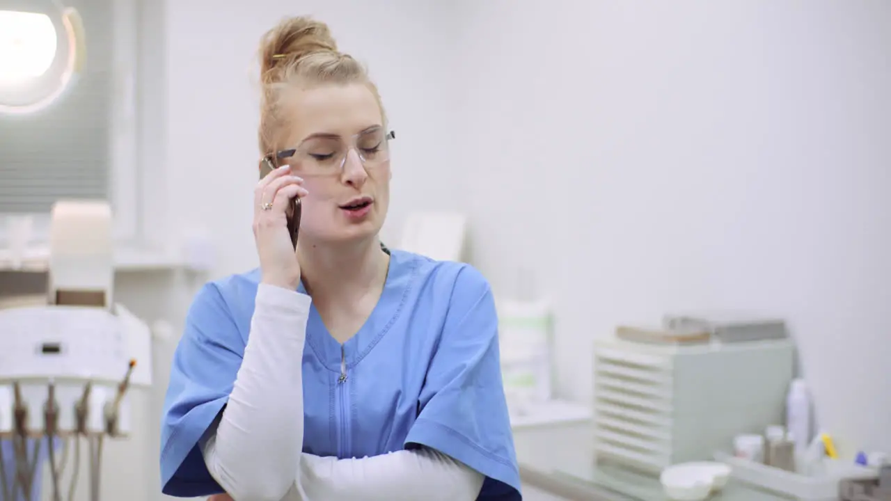 Female Doctor Talking On Mobile Phone At Healthcare Clinic 1