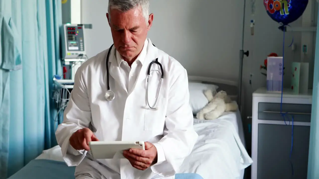 Male doctor using digital tablet in ward