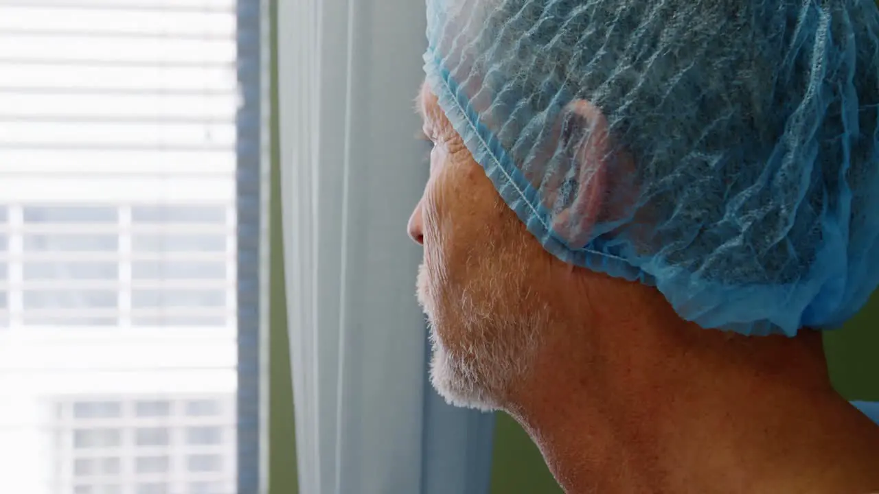 Thoughtful doctor standing near window