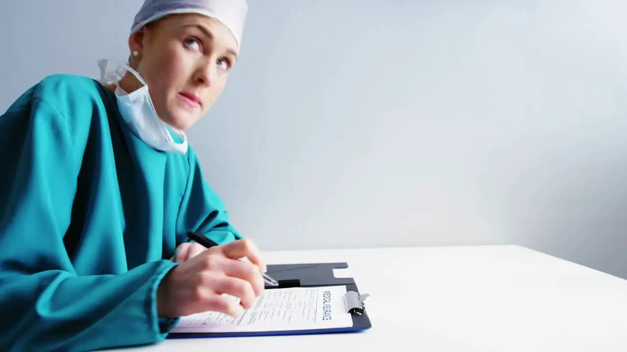 Female doctor writing on clipboard