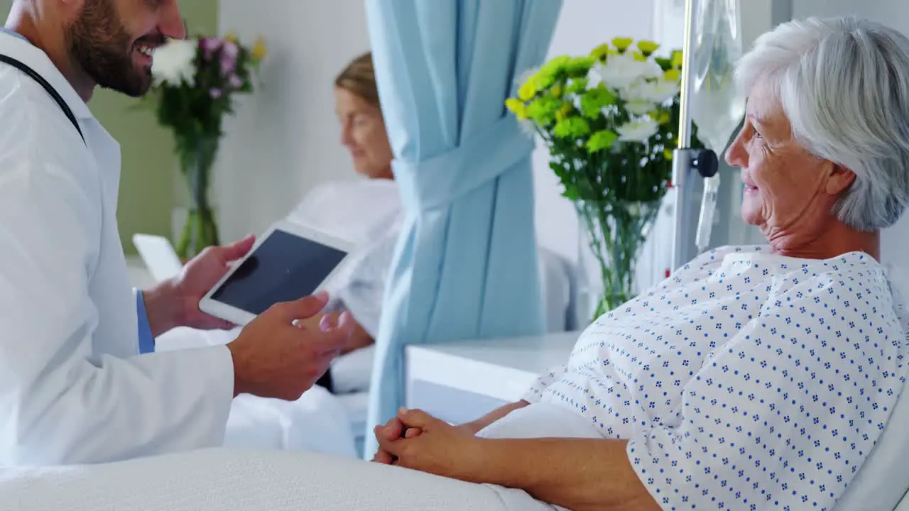 Male doctor discussing medical report with senior woman on digital tablet