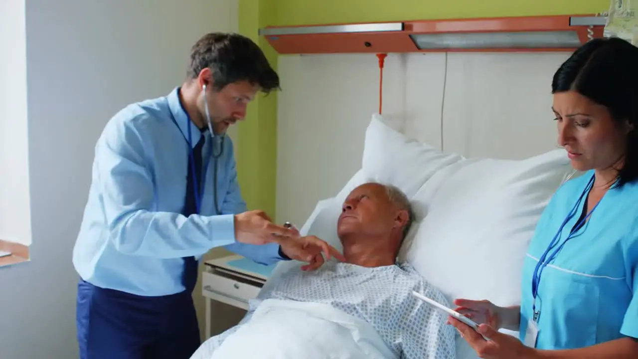 Nurse using digital tablet while doctor examining a patient