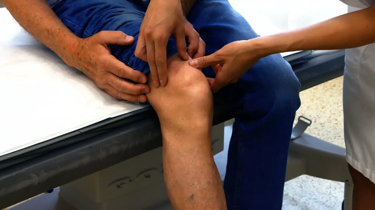 Female doctor examining patients knee