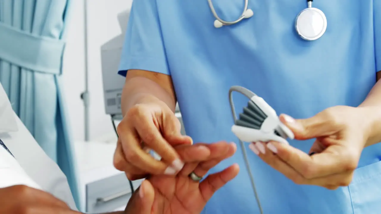 Female doctor operating heartbeat machine