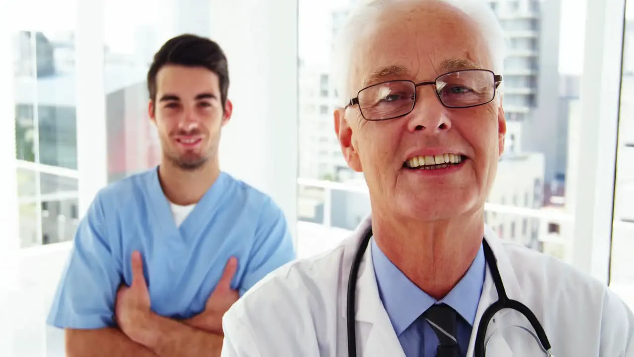 Portrait of male doctors and coworker standing with arms crossed