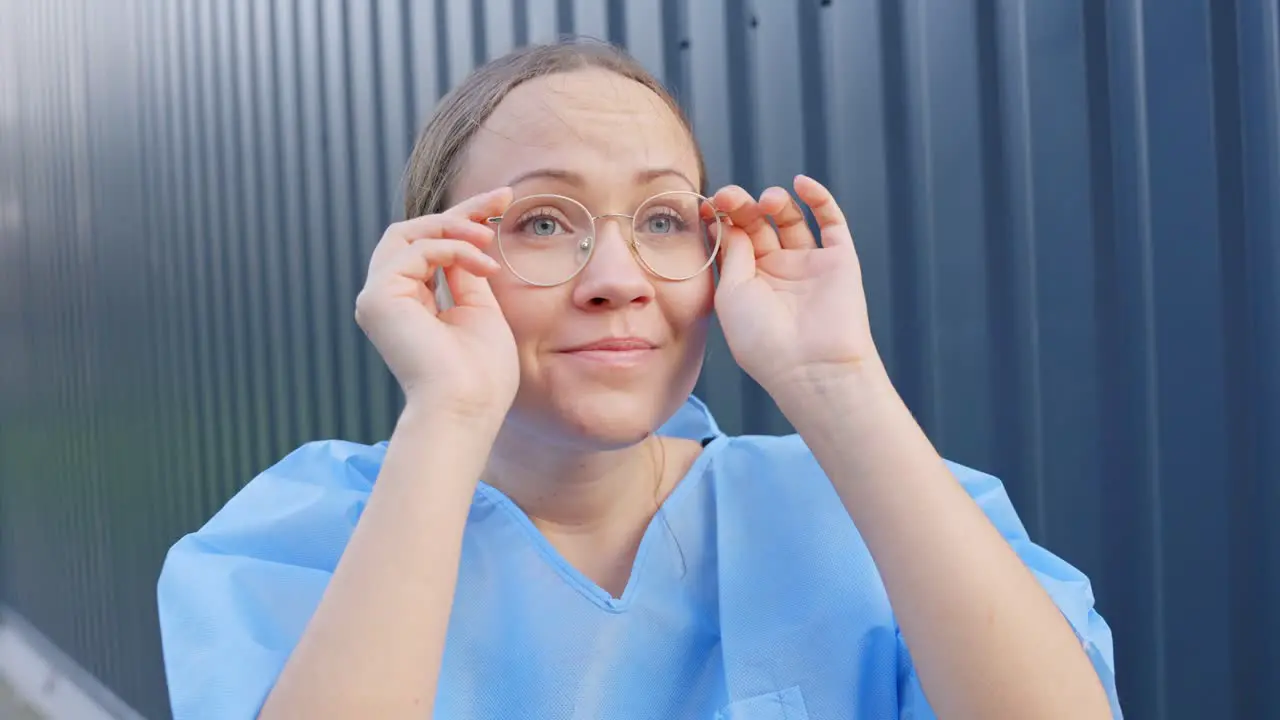 Optimistic Female Doctor Putting on Glasses Looking Towards Bright Future