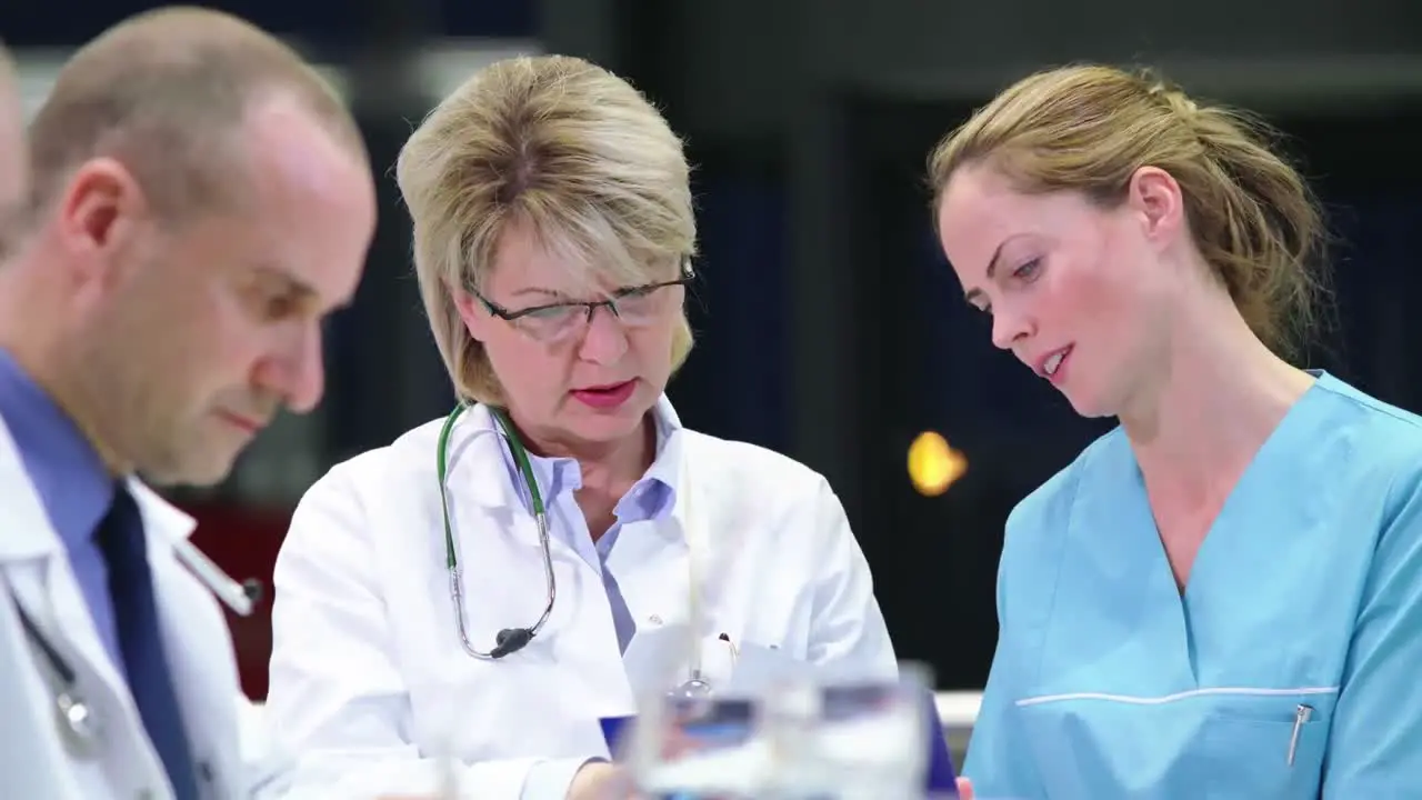 Doctor and nurse discussing over medical report in conference room