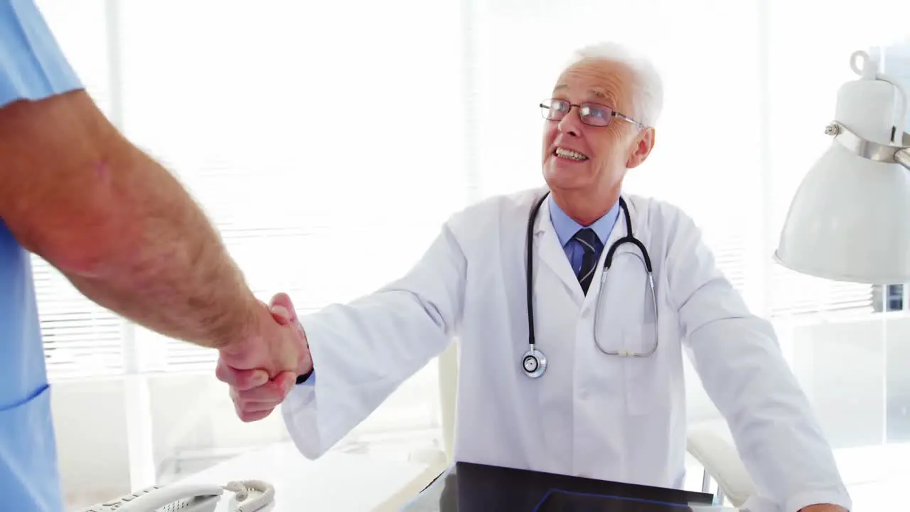 Male doctor shaking hands with coworker