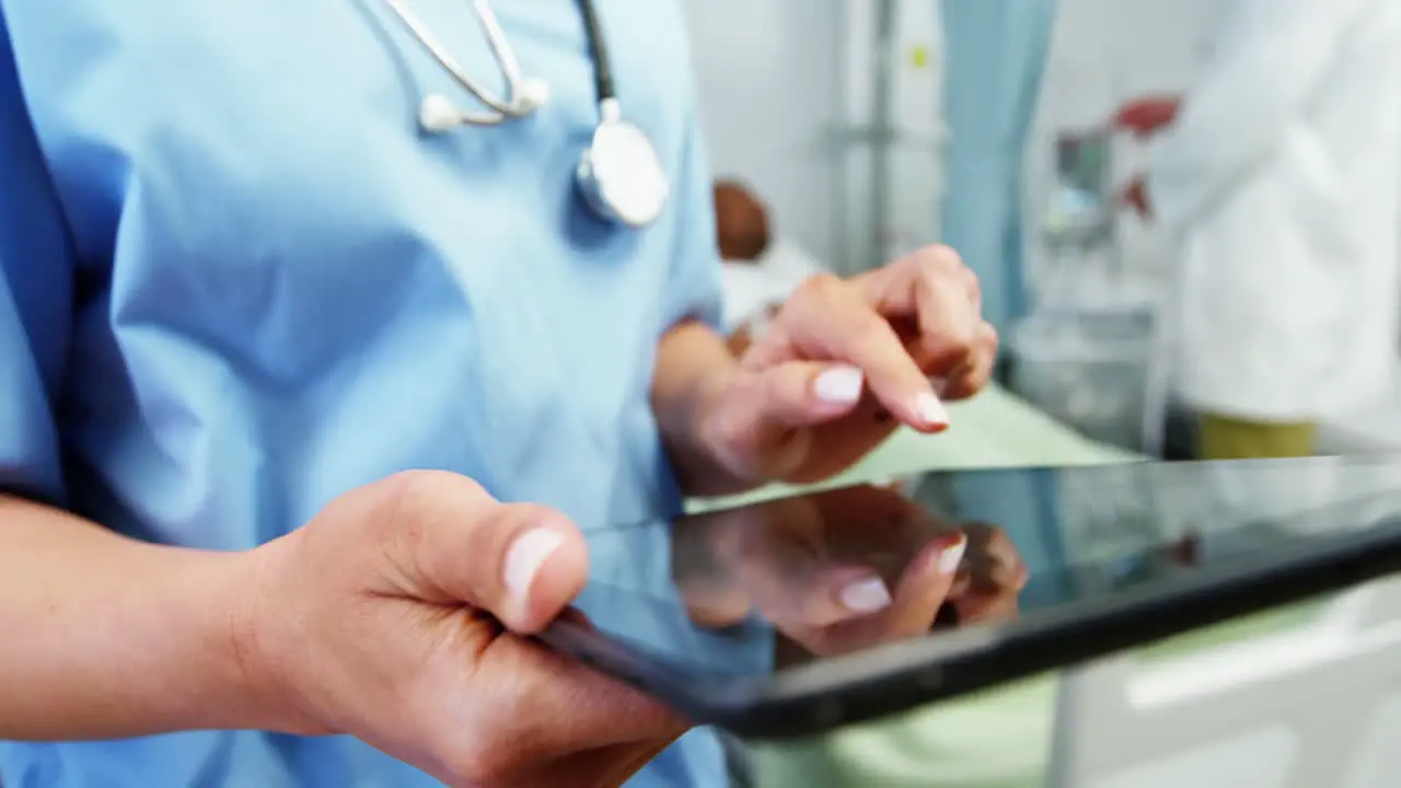 Mid section of female doctor using digital tablet