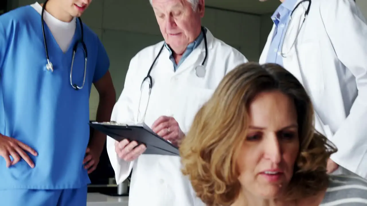 Nurse and doctor discussing over clipboard in corridor 