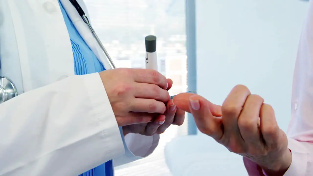 Female doctor measuring sugar level of patient with glucometer