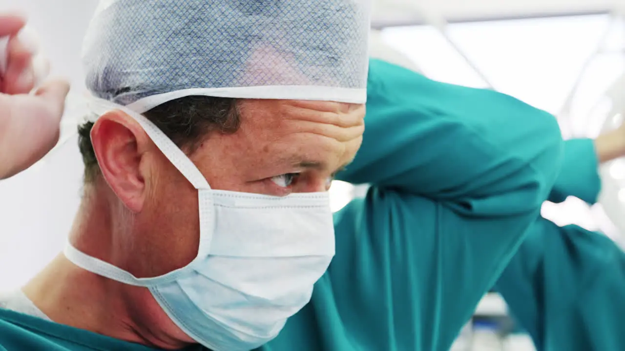 Surgeon tying surgical mask