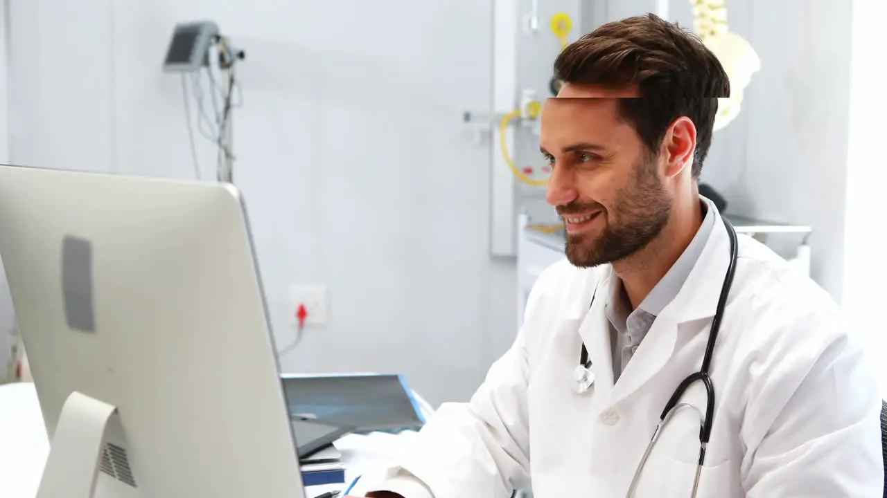 Portrait of male doctor working on computer at desk