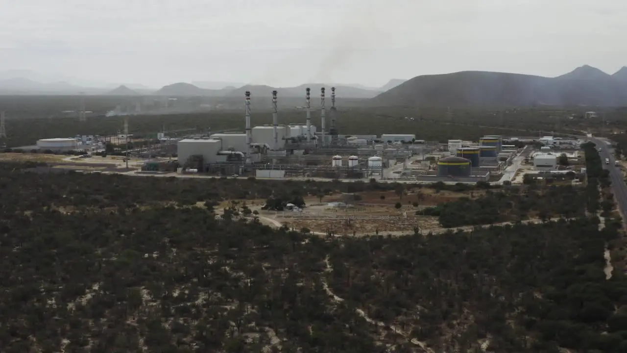 Drone shot rising over a gas-fired power station in a desert in Mexico