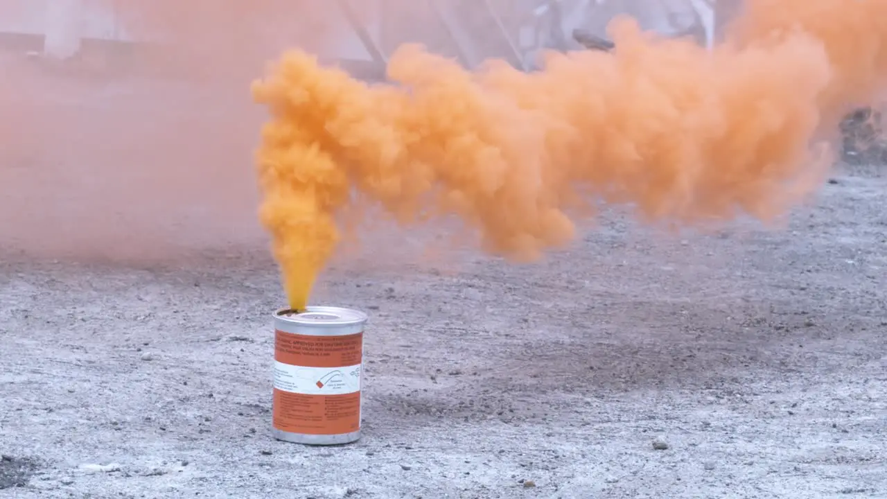 Vibrant orange smoke grenade going up into the sky