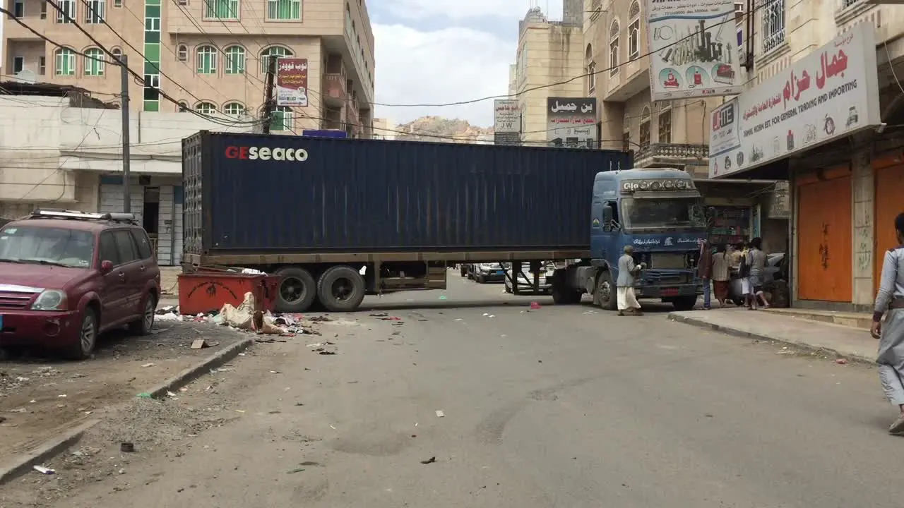 a big truck is blocking the street because of bad driver while carring container