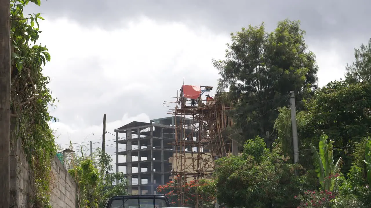 Workers are building a new building using local woods to build scafolding