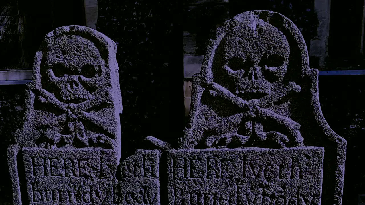 Ancient tombstones in a churchyard at night in a thunderstorm in Faversham Kent