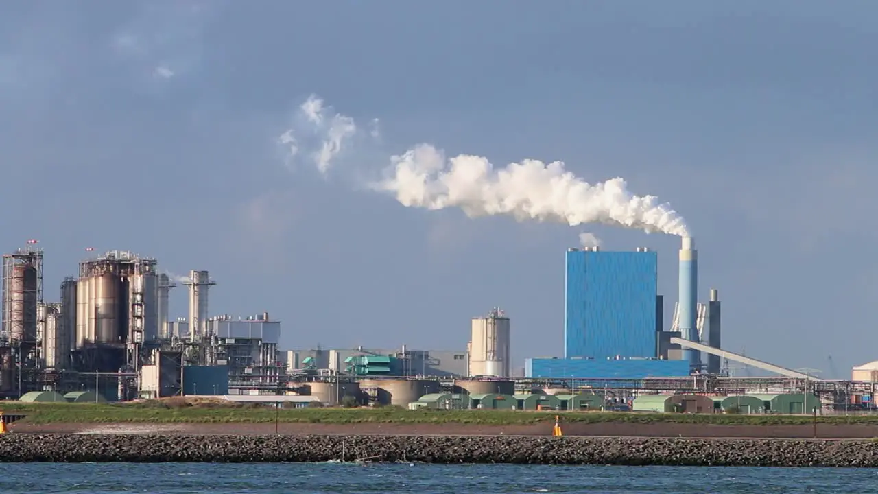 Emissions from industrial chimney near port with factories