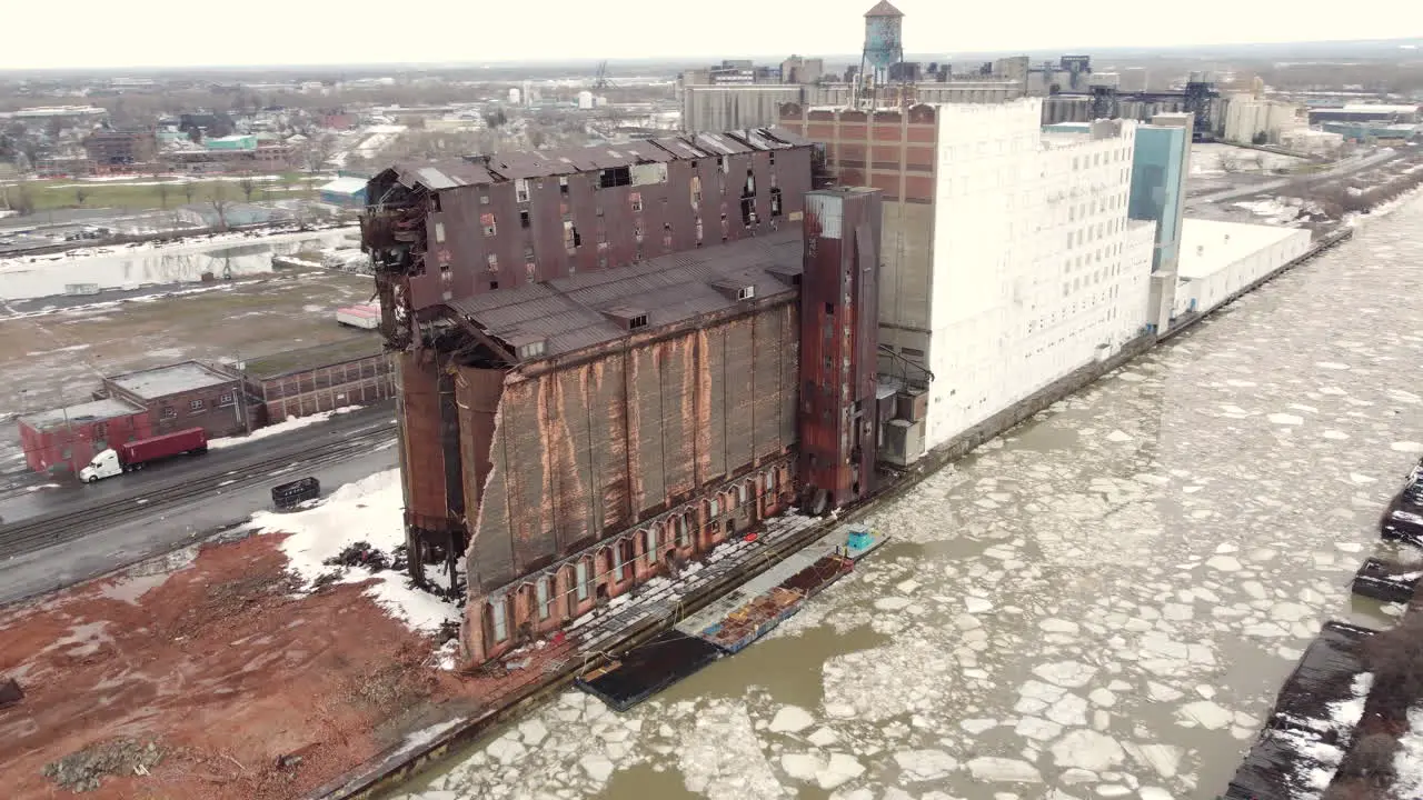 Large abandoned factory next to frozen river