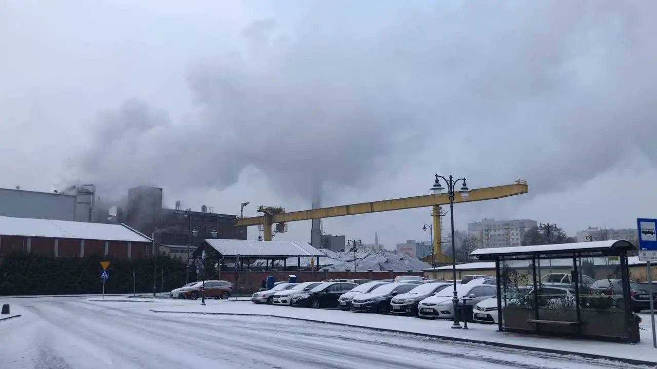 Car parking in front of sugar factory in Malbork Poland smoke rising from chimneys