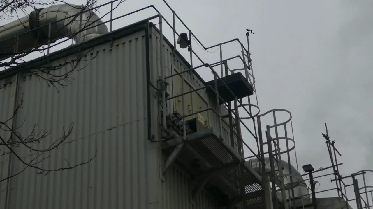 Industrial warehouse pipes steaming on roof cooling system vent pipeline