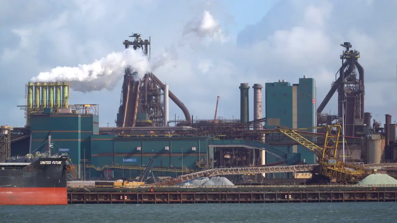 Pipes with emission by steel plant on the harbor side in broad daylight