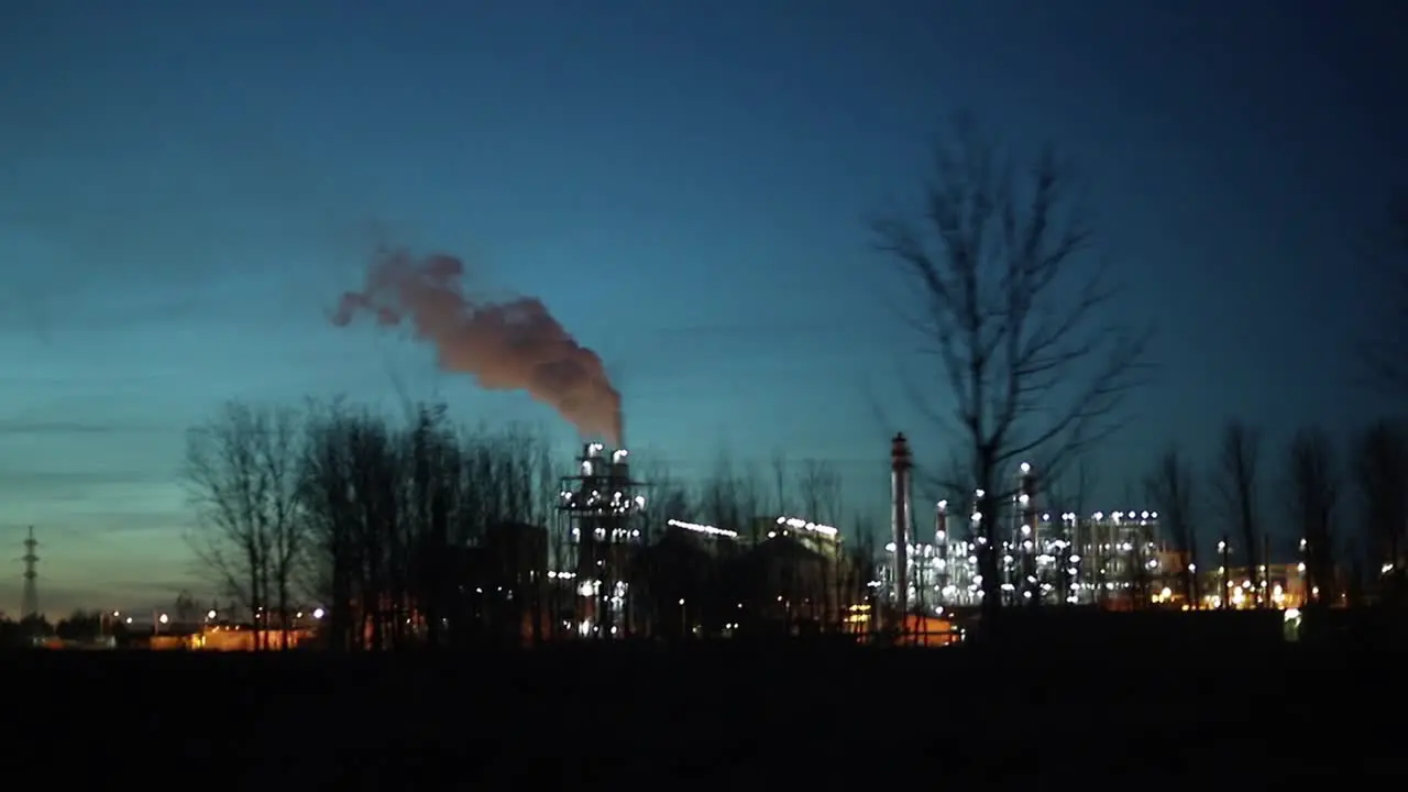 Industrial zone with a large pipe thick white smoke is poured from the factory pipe at night